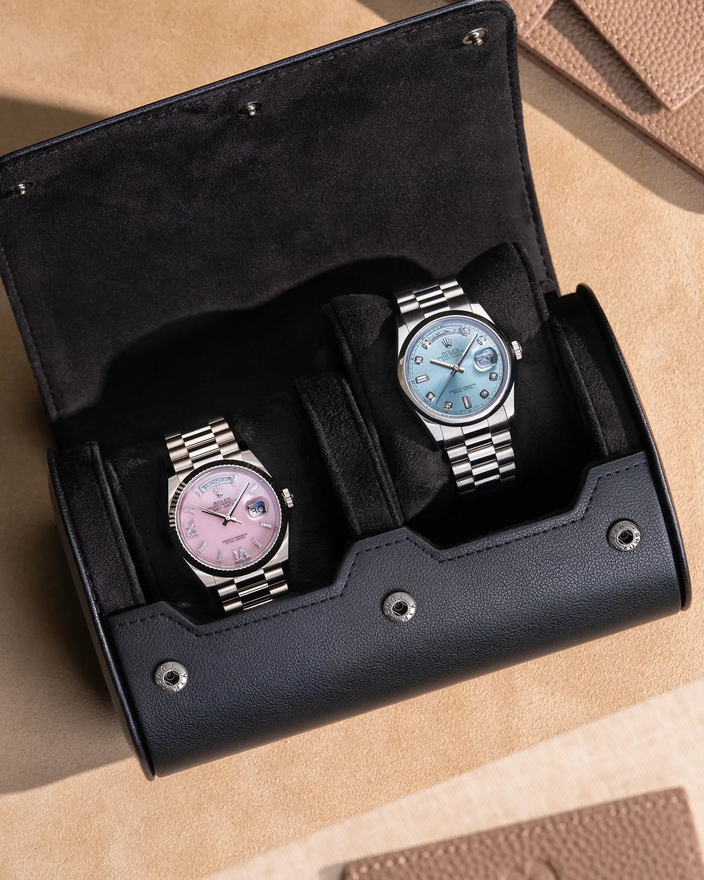 Two luxury watches displayed in an open black 2 Slot Watch Roll, showcasing a refined velvet interior for elegant and secure storage.