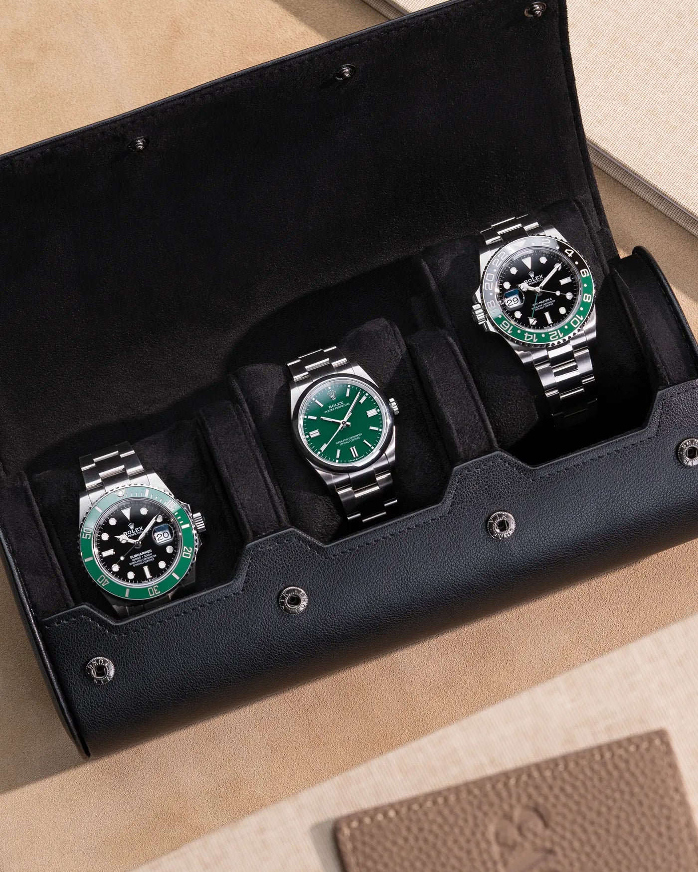 Three premium watches securely displayed in an open black 3 Slot Watch Roll with a soft velvet interior, perfect for travel or home storage.
