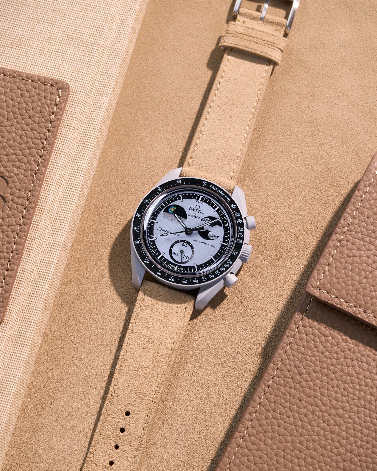 Flat lay Moonswatch Mission to Earthphase with Beige suede leather strap