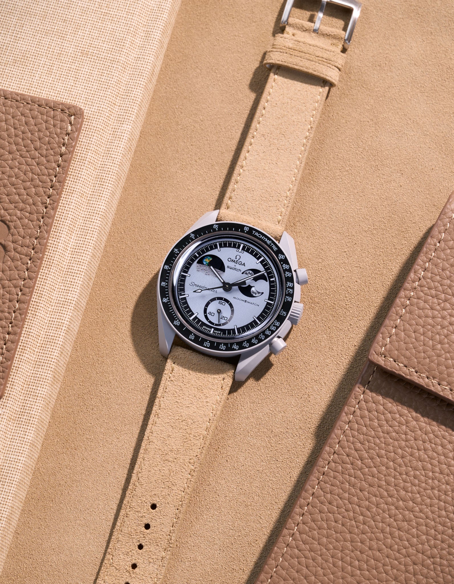 Flat lay Moonswatch Mission to Earthphase with Beige suede leather strap