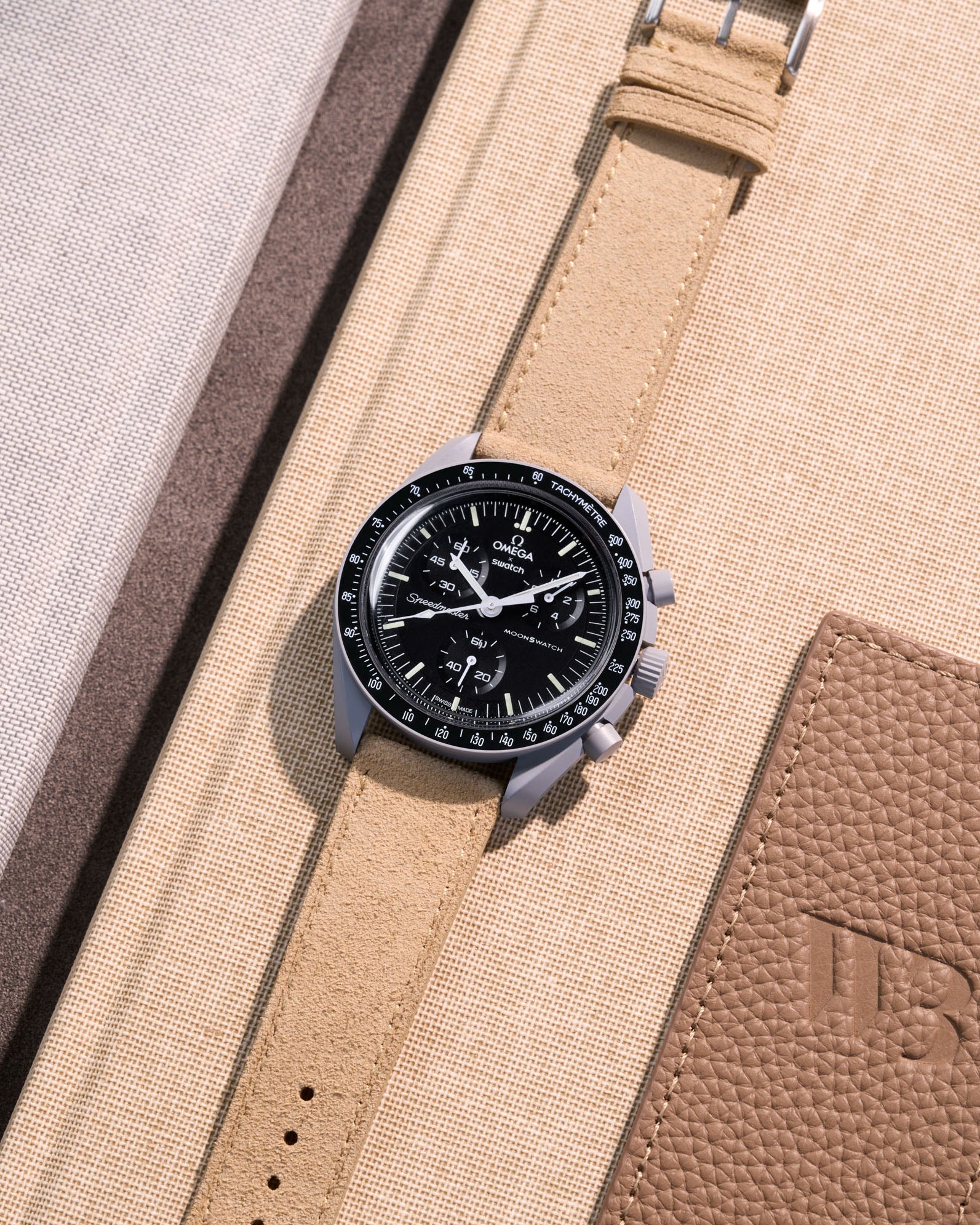 Flat lay Moonswatch Mission to the Moon with Beige suede leather strap