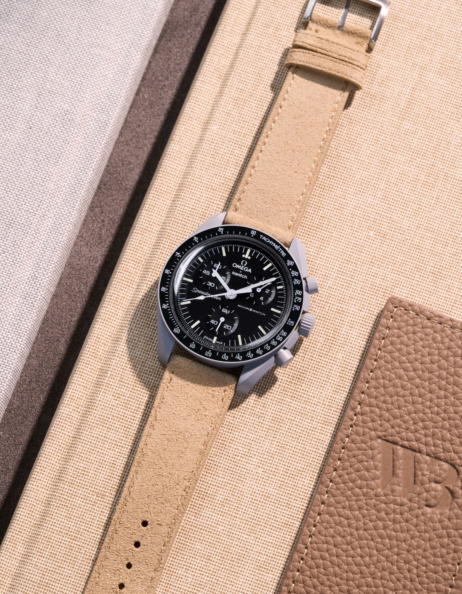 Flat lay Moonswatch Mission to the Moon with Beige suede leather strap