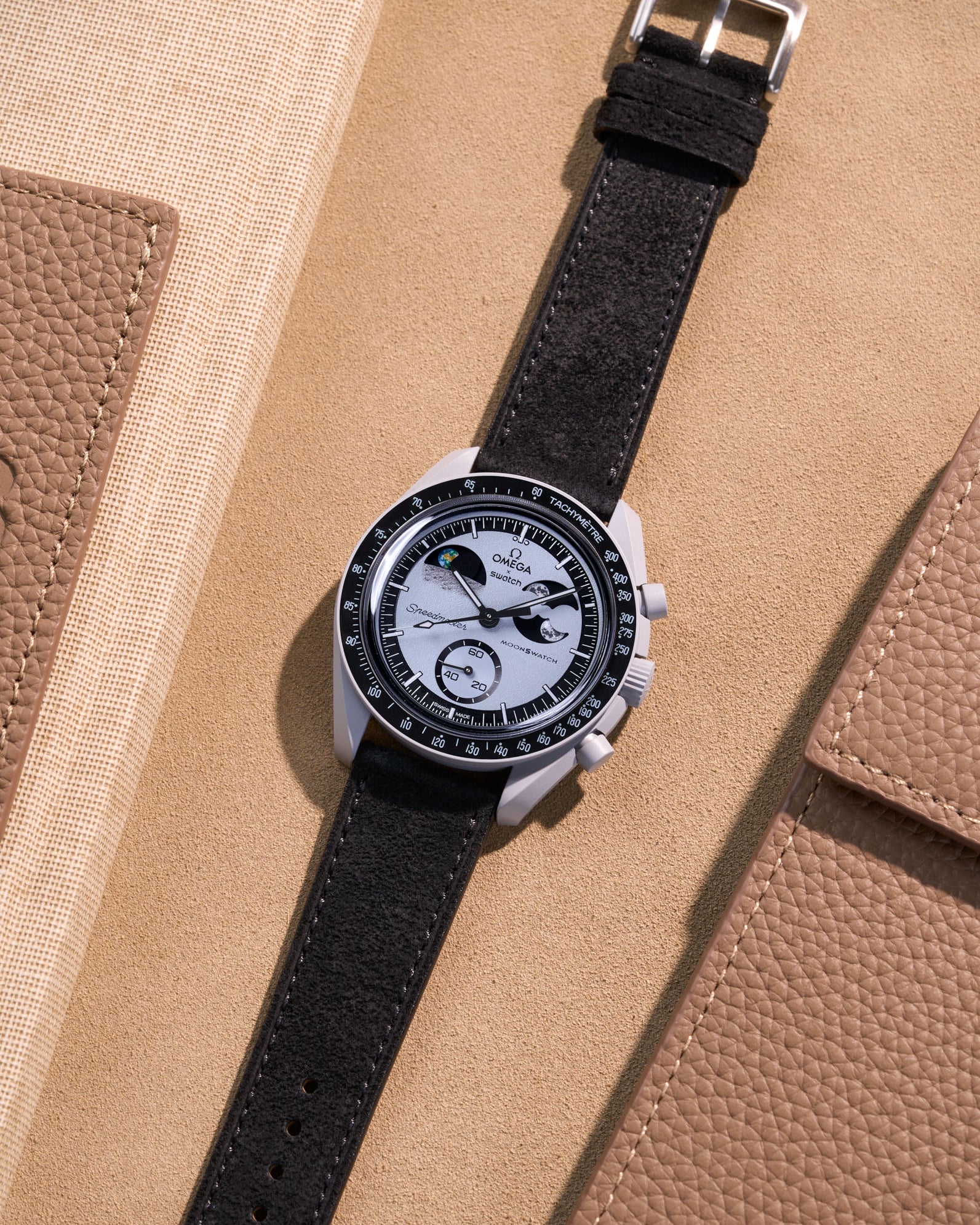 Flat lay Moonswatch Mission to Earthphase with Black suede leather strap