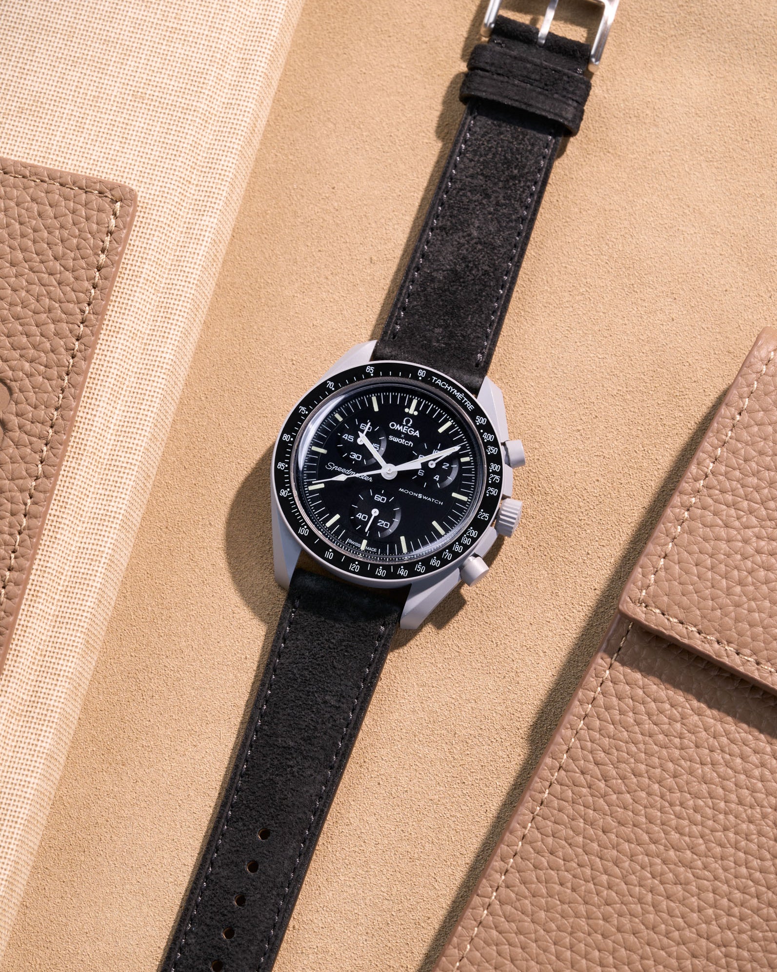 Flat lay Moonswatch Mission to the Moon with Black suede leather strap