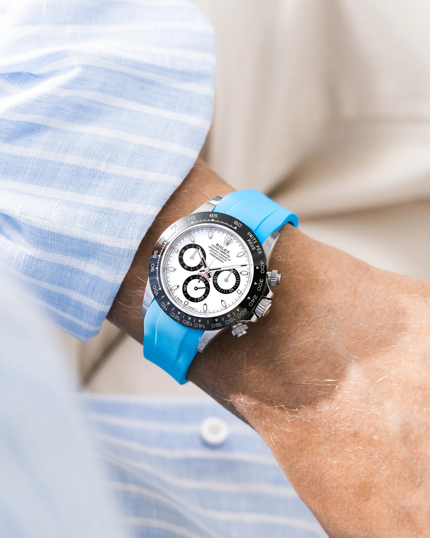 Capri Blue integrated FKM rubber strap with original clasp on Rolex Daytona 116500 white dial ceramic bezel wrist shot with blue and white shirt