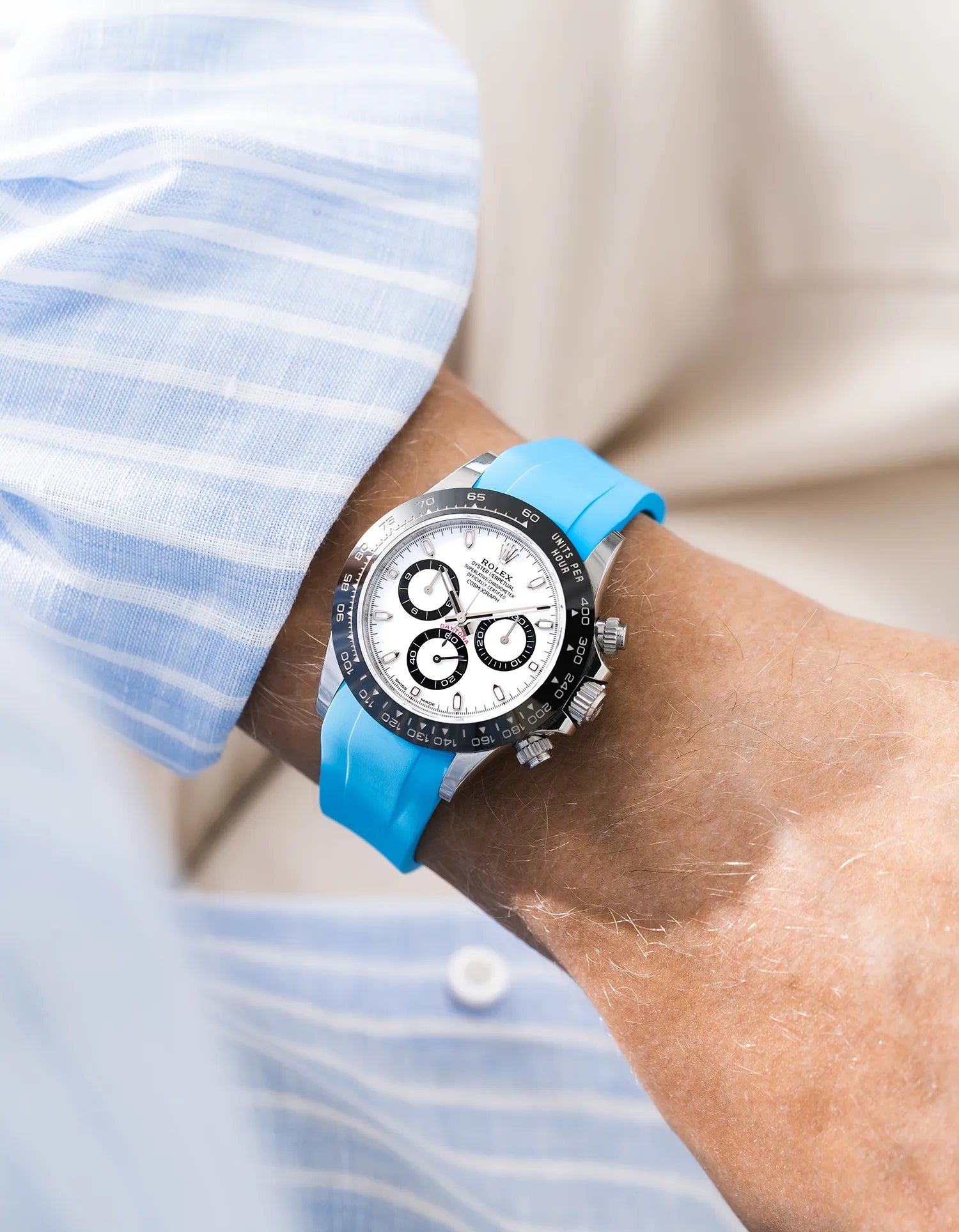 Capri Blue integrated FKM rubber strap with original clasp on Rolex Daytona 116500 white dial ceramic bezel wrist shot with blue and white shirt