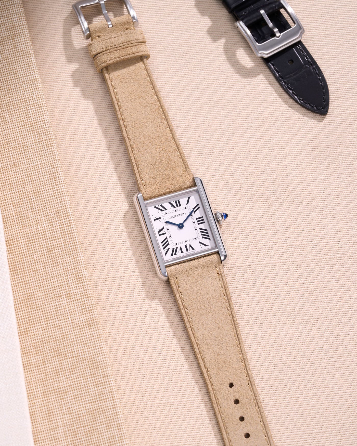 Cartier watch with beige suede strap.
