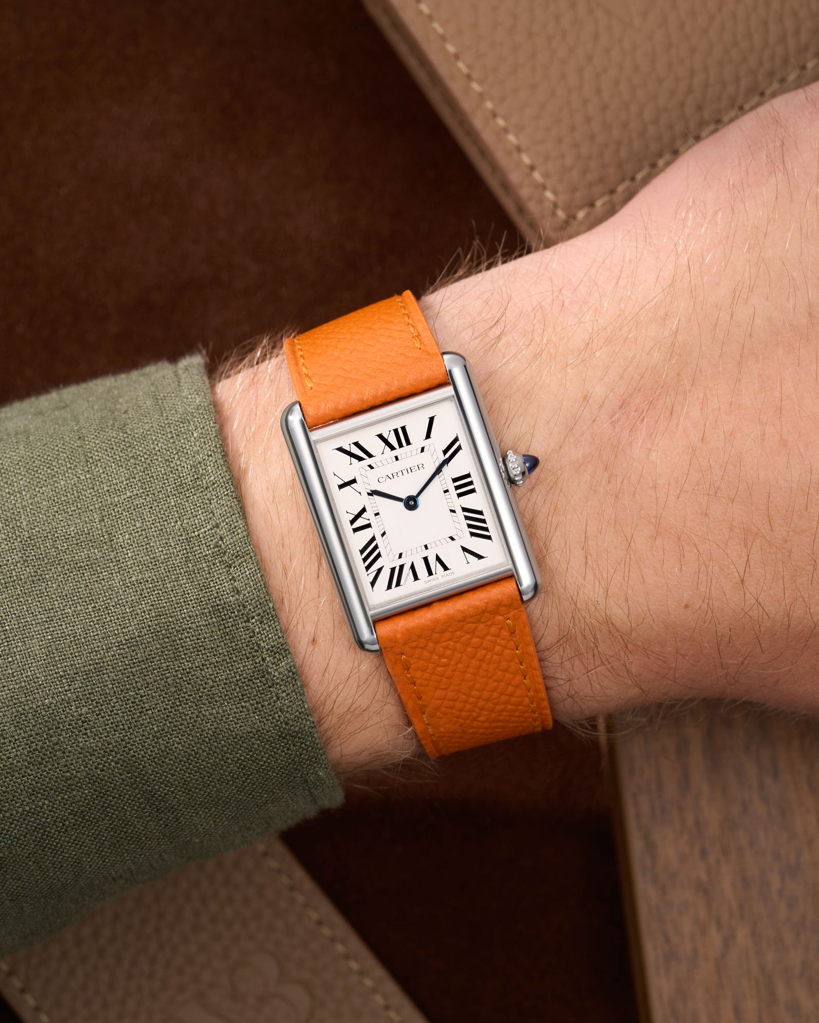 Orange Epsom Leather Straps for Cartier Tank Must Large wrist shot with a green Shirt