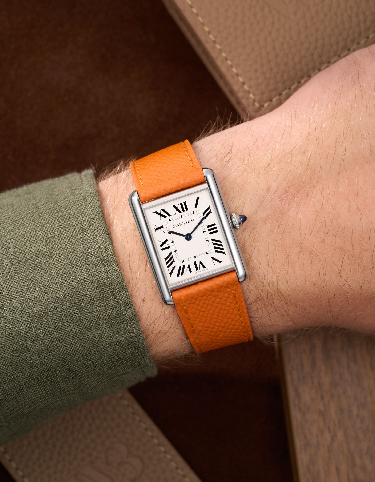 Orange Epsom Leather Straps for Cartier Tank Must Large wrist shot with a green Shirt