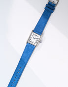 Cartier Tank Must Large watch with Ocean Blue Suede Leather strap, lying flat on white background