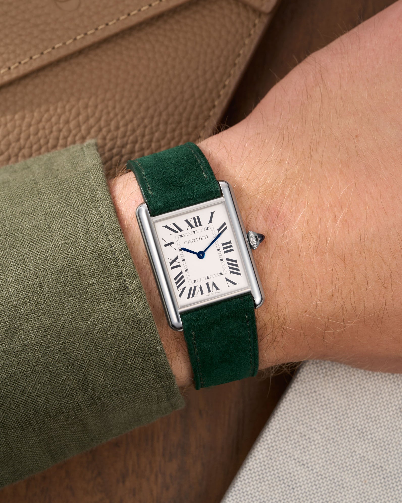 Green Suede Leather Straps for Cartier Tank Must Large wrist shot over brown table