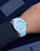 Turquoise Rubber Strap on Omega X Swatch MoonSwatch Mission to Uranus wrist shot with dark blue shirt and blue background