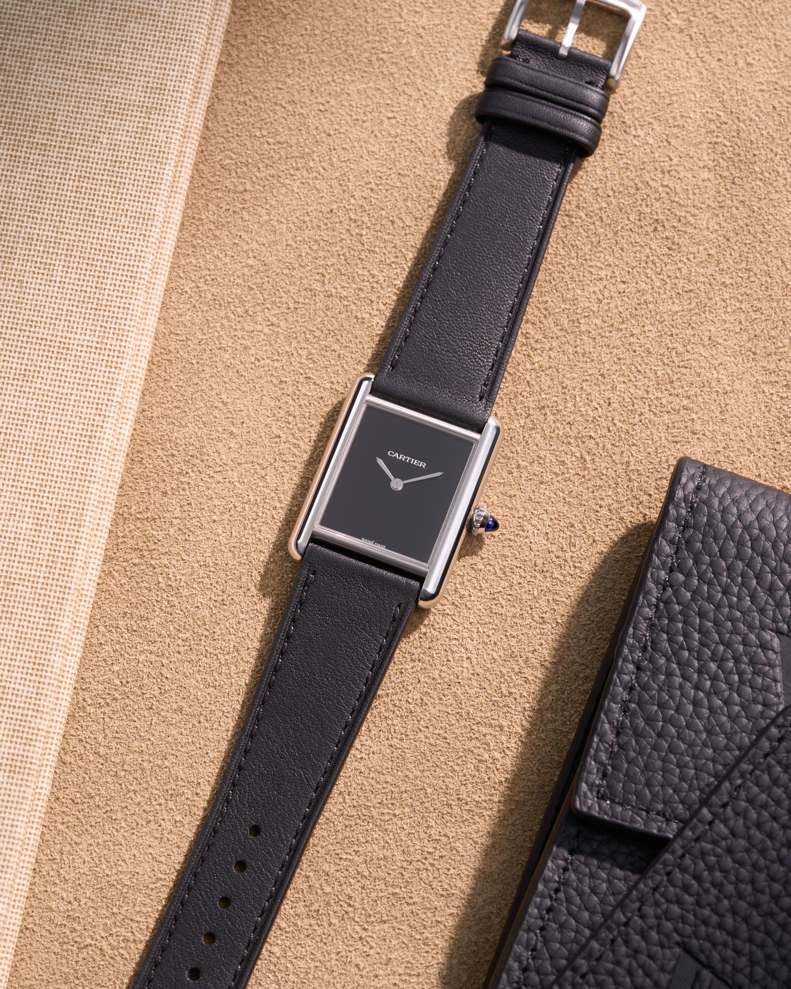 Cartier Tank Must Large featuring Black cowhide leather strap, watch facing up on table surface