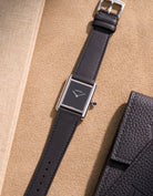Cartier Tank Must Large featuring Black cowhide leather strap, watch facing up on table surface