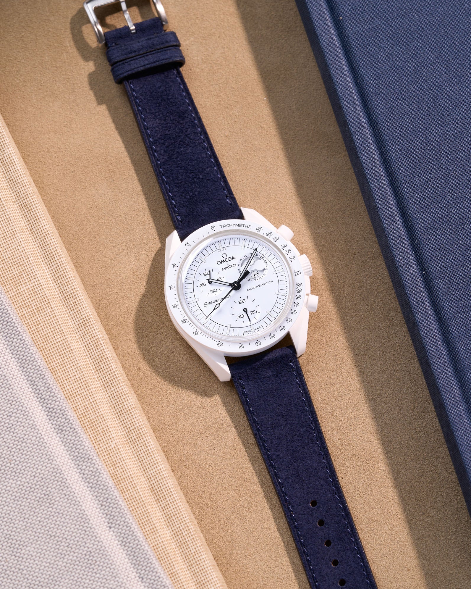 Flat lay Moonswatch Mission to the Moonphase Full Moon with Dark Blue suede leather strap