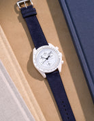 Flat lay Moonswatch Mission to the Moonphase Full Moon with Dark Blue suede leather strap