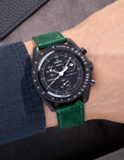 Omega X Swatch Mission to the Moonphase New Moon with dark green suede leather strap worn on wrist