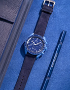 Flat lay Moonswatch Mission to Neptune with Dark Blue suede leather strap