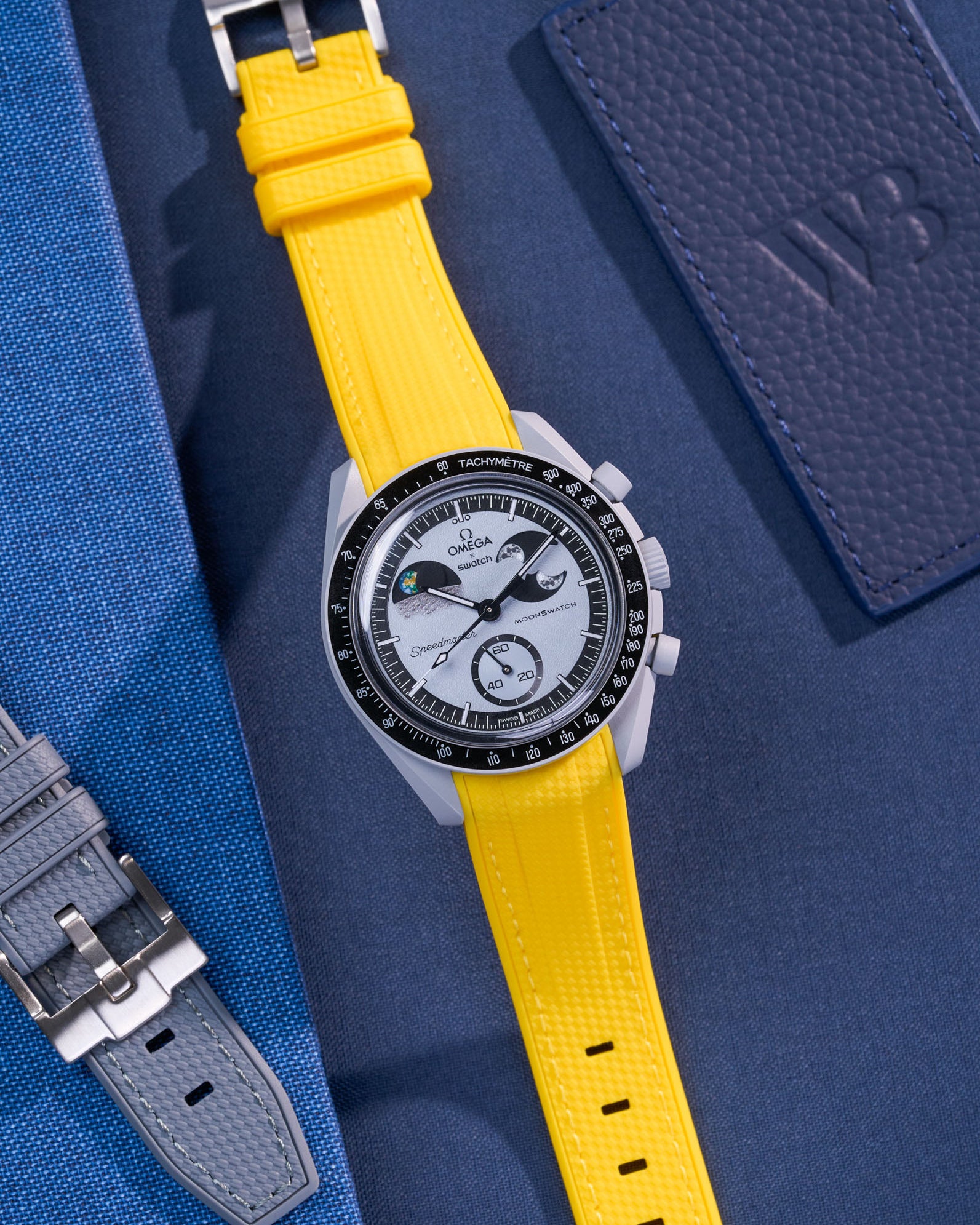 Flat lay of Omega X Swatch MoonSwatch Mission to EarthPhase with yellow rubber strap, watch facing up with clasp visible
