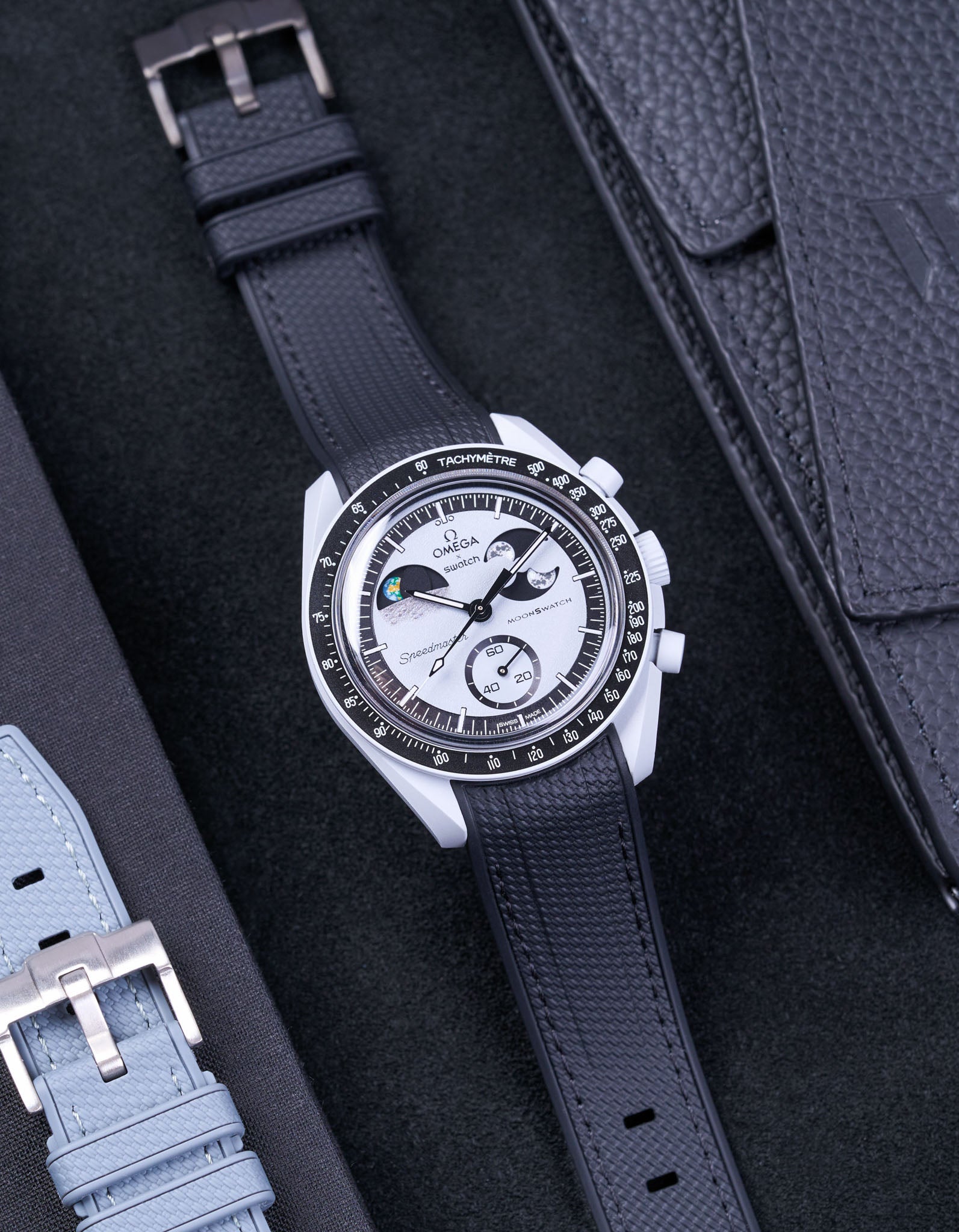 Flat lay of Vertech Omega X Swatch MoonSwatch Mission to EarthPhase with black rubber strap, watch facing up with clasp visible
