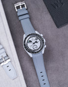 Flat lay of Vertech Omega X Swatch MoonSwatch Mission to EarthPhase with dark grey rubber strap, watch facing up with clasp visible