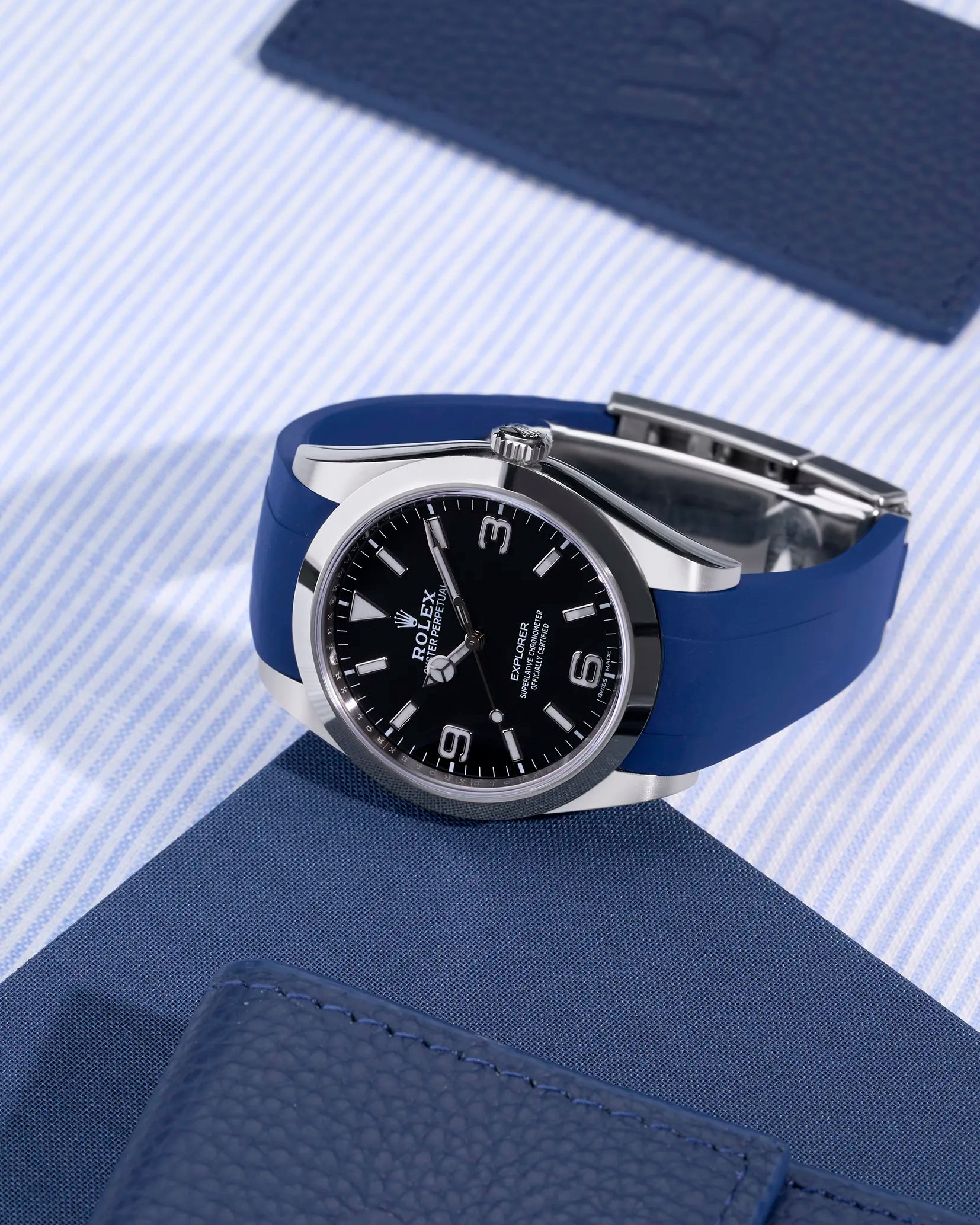 Rolex Explorer 214270 on blue FKM rubber strap integrated with original clasp – angled studio shot