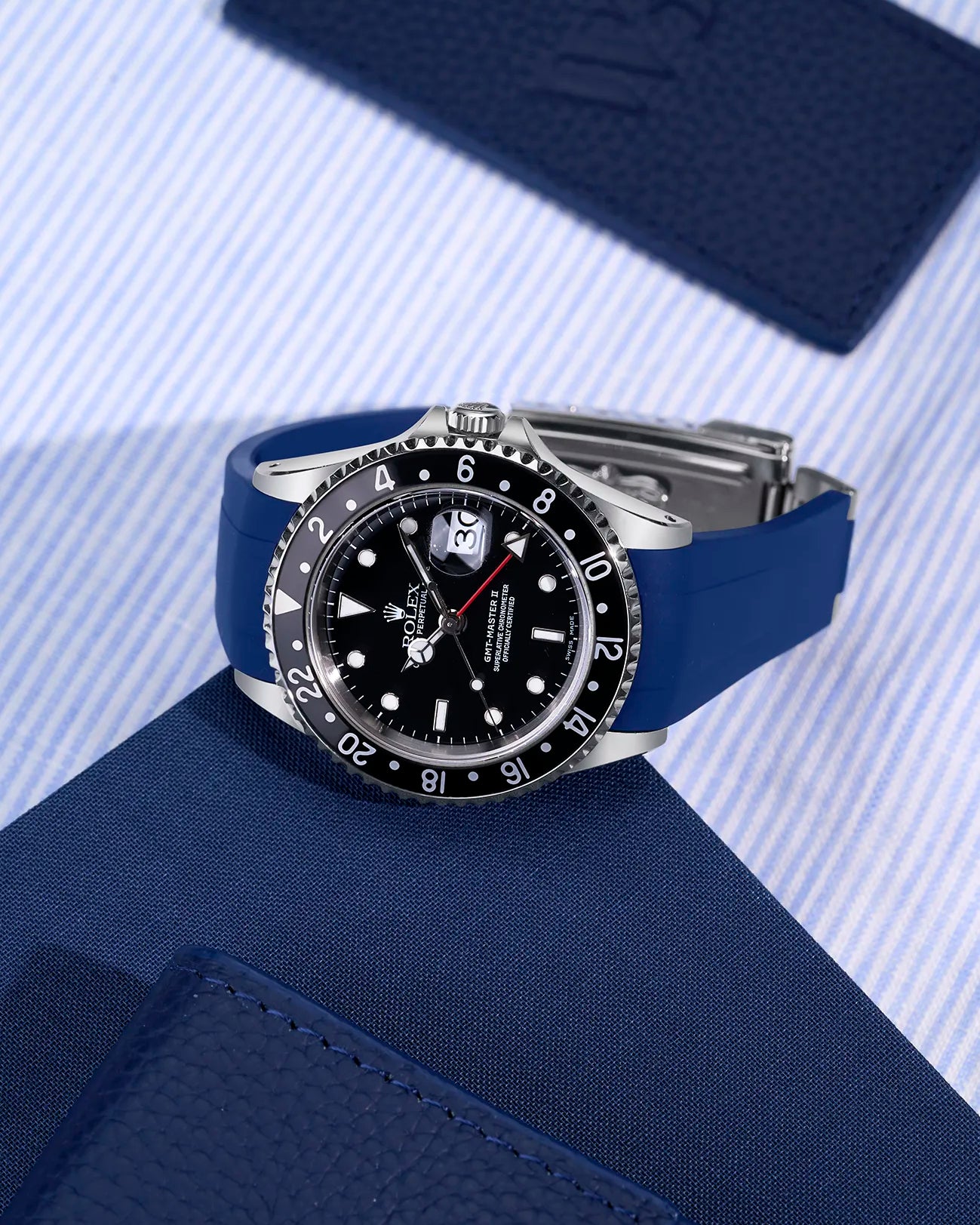 Blue rubber strap fitted on Rolex GMT-Master II 16710 with original clasp – flat lay showcasing seamless integration