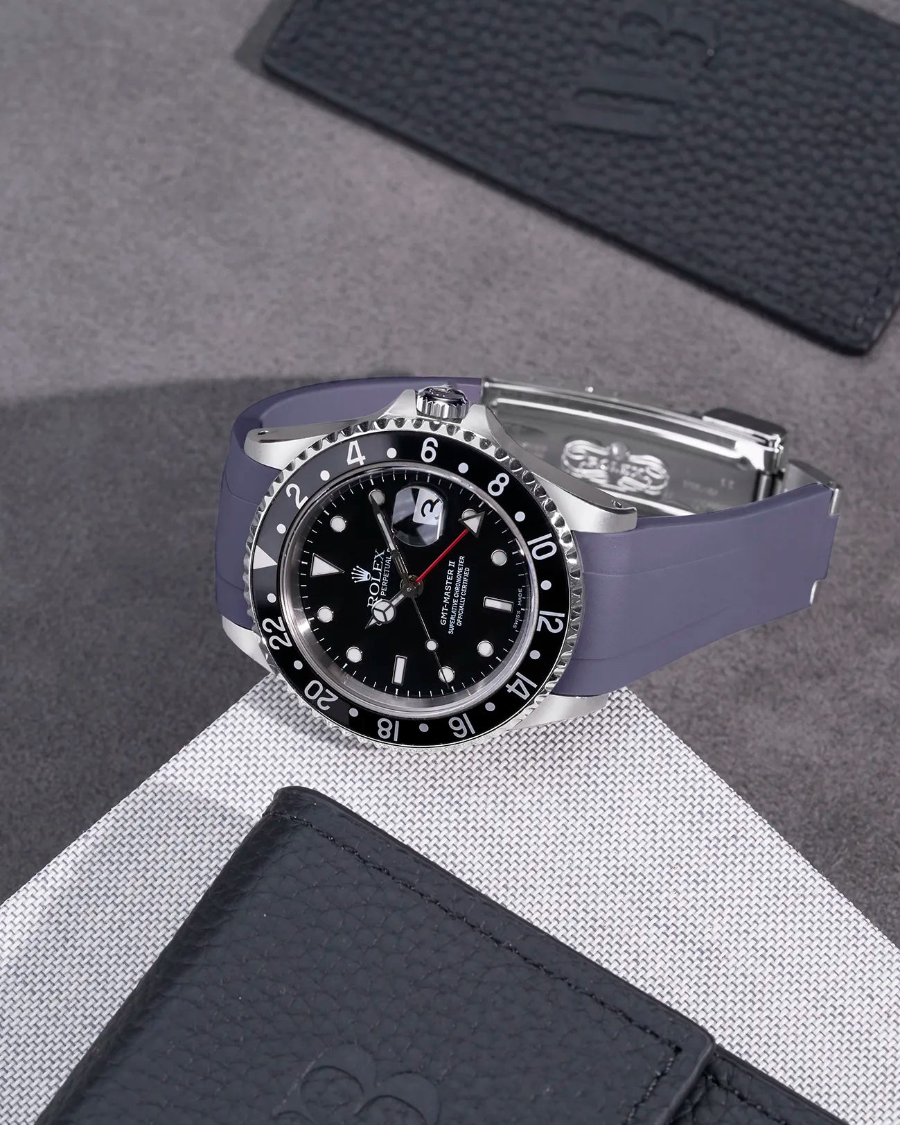 Rolex GMT-Master II 16710 and 16713 fitted with grey rubber strap and original clasp – flat lay on textured surface