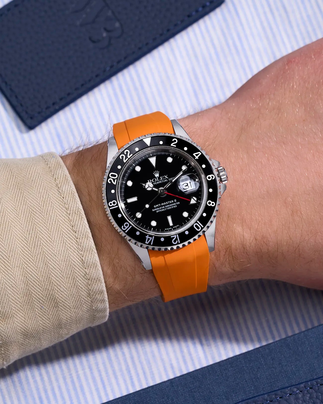 Wrist shot of Rolex GMT-Master II 16710 and 16713 on orange rubber strap with original clasp integration