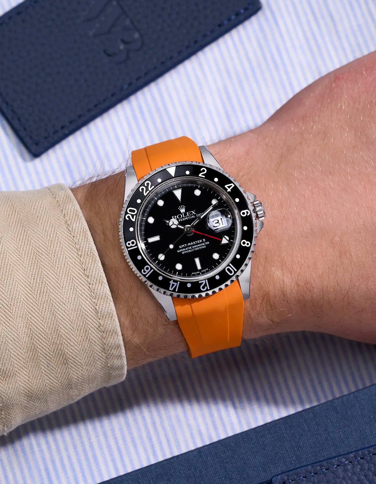 Wrist shot of Rolex GMT-Master II 16710 and 16713 on orange rubber strap with original clasp integration