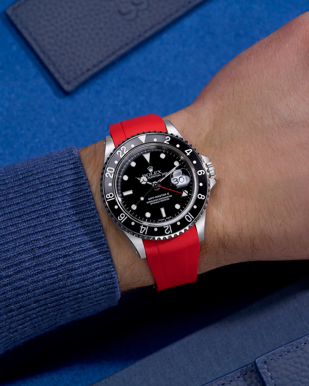 Wrist shot of Rolex GMT-Master II 16710 and 16713 on red rubber strap integrated with original Rolex clasp