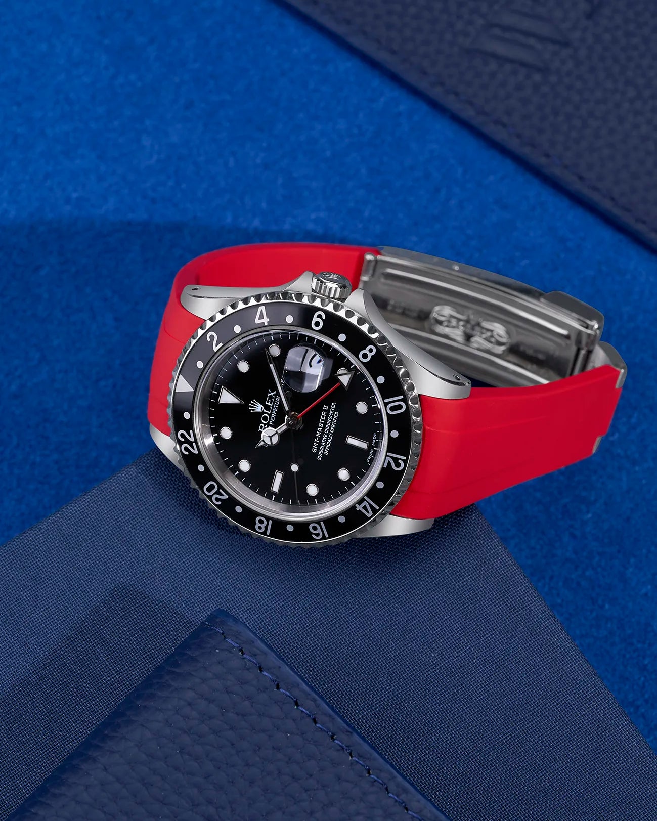 Rolex GMT-Master II 16710 and 16713 fitted with red FKM rubber strap and original clasp – flat lay on blue background