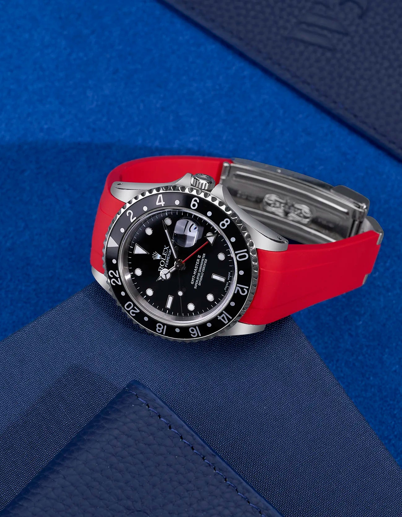 Rolex GMT-Master II 16710 and 16713 fitted with red FKM rubber strap and original clasp – flat lay on blue background