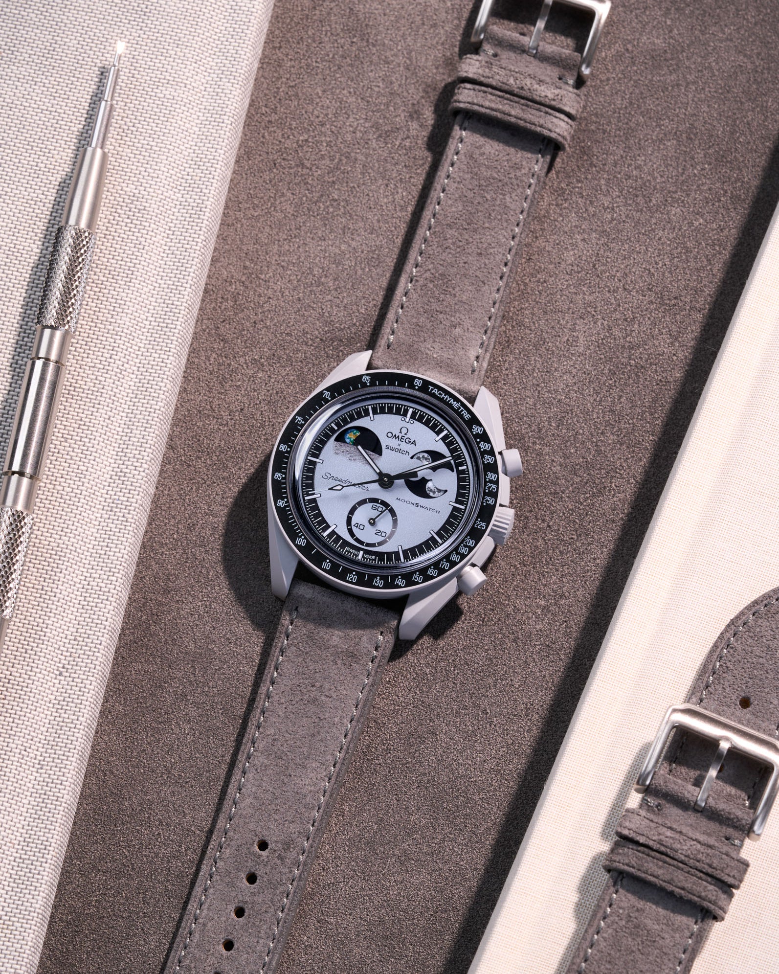 Flat lay Moonswatch Mission to Earthphase with Grey suede leather strap