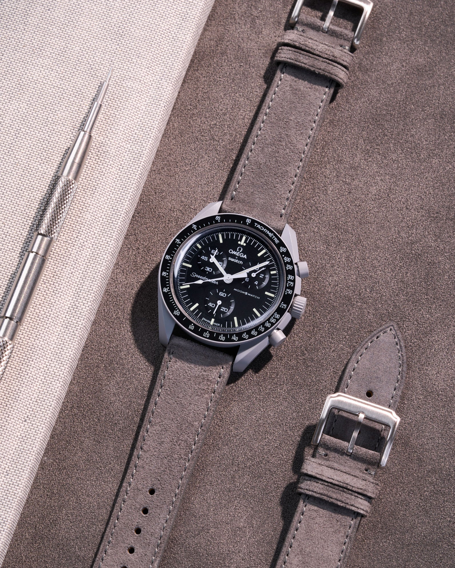 Flat lay Moonswatch Mission to the Moon with grey suede leather strap