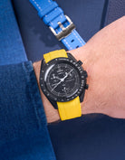MoonSwatch Mission to Moonphase New Moon on the wrist with vertech yellow rubber strap styled with blue shirt