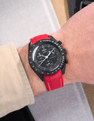 MoonSwatch Mission to Moonphase New Moon on the wrist with vertech red rubber strap with white stitching styled with beige shirt