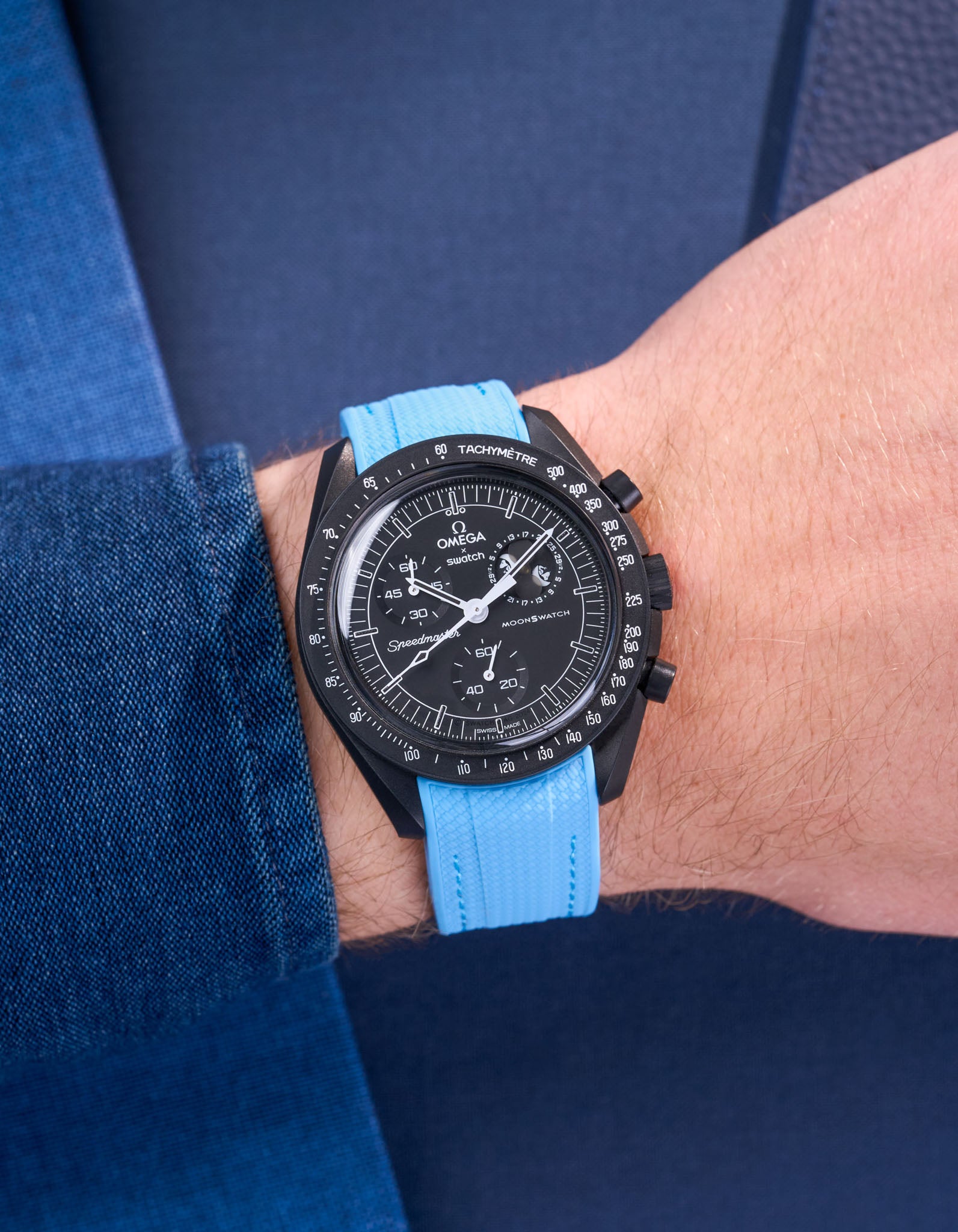 MoonSwatch Mission to Moonphase New Moon on the wrist with capri blue rubber strap styled with blue shirt