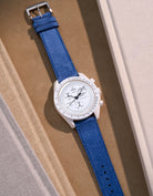 Flat lay Moonswatch Mission to the Moonphase Full Moon with Ocean Blue suede leather strap