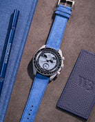 Flat lay Moonswatch Mission to Earthphase with Ocean blue suede leather strap
