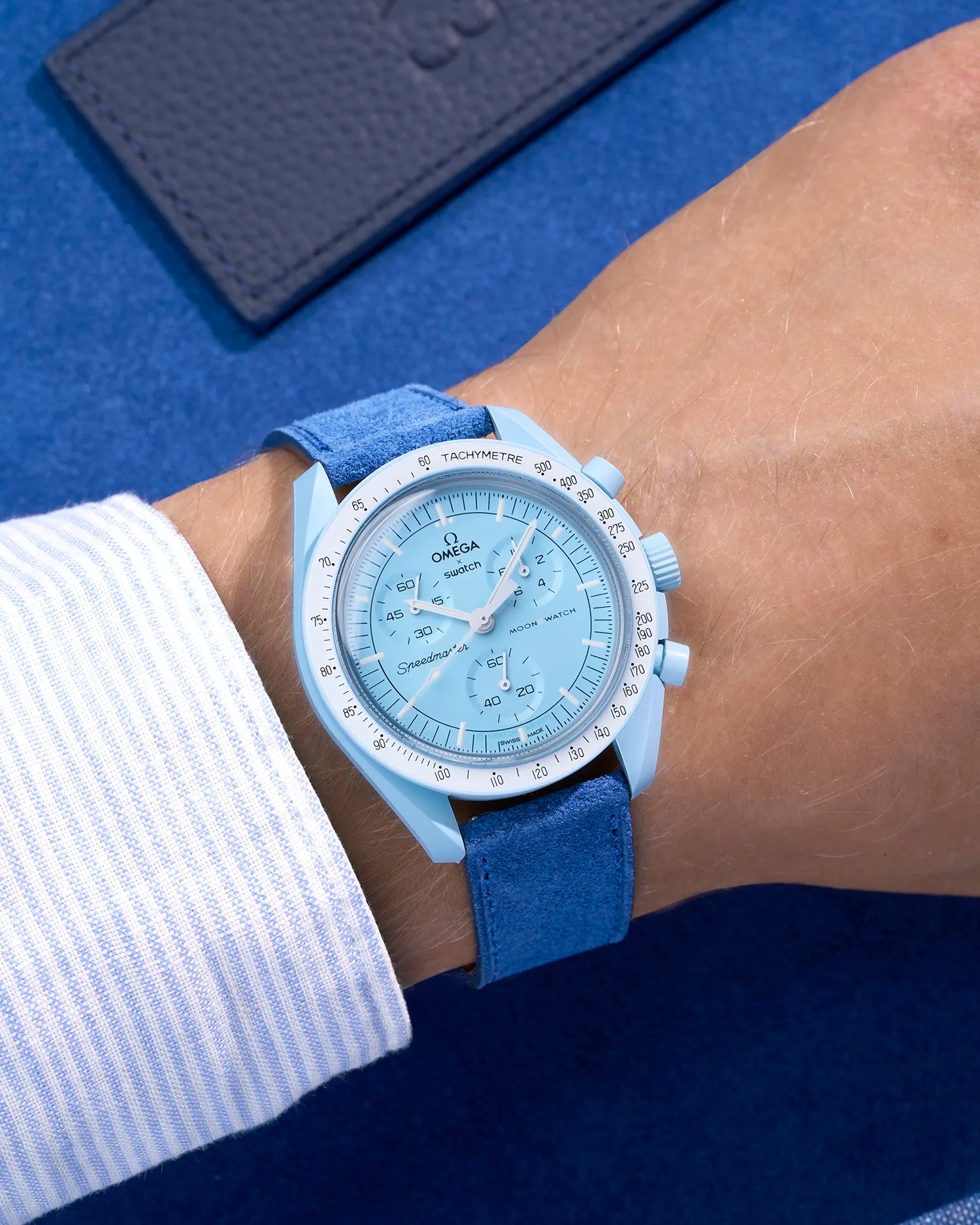 Omega X Swatch Mission to Uranus with Ocean Blue suede leather strap worn on wrist – styled shot in earthy neutral tones