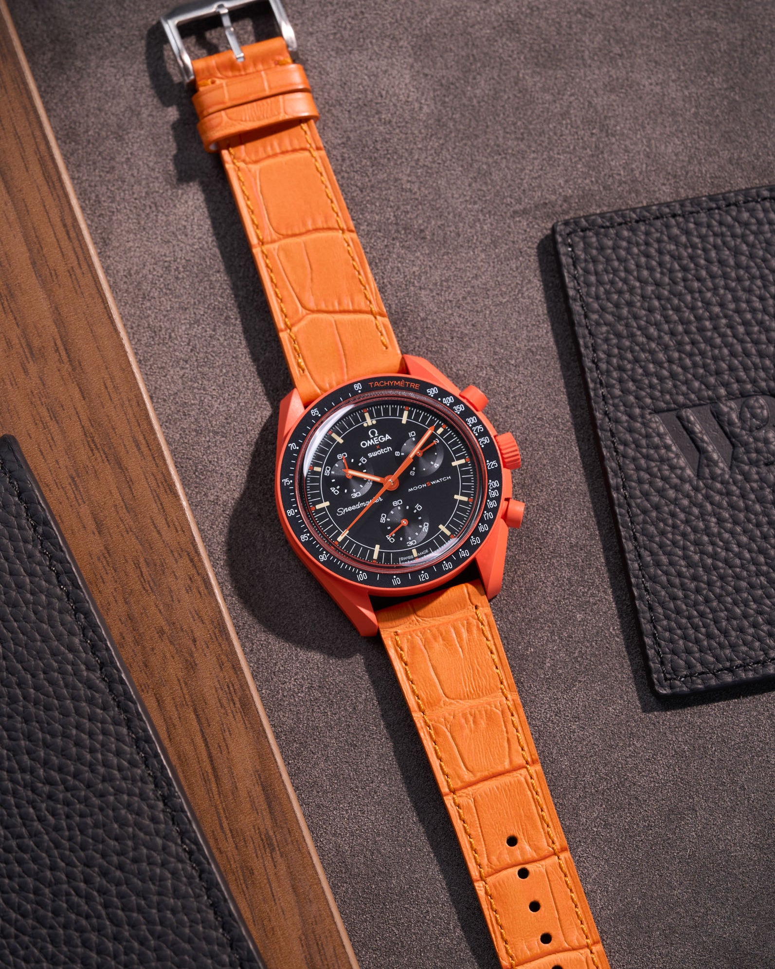 Flat lay of orange embossed alligator leather strap for Omega x Swatch MoonSwatch mission on Earth Lava