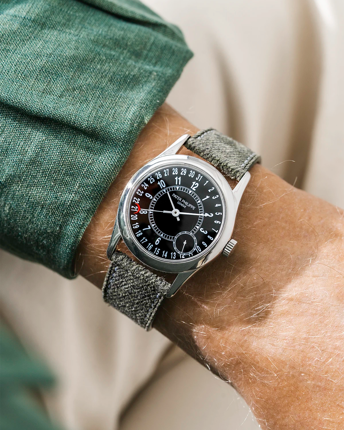 Patek Calatrava on a green denim leather watch strap from Wristbuddys on a persons wrist wearing a green shirt