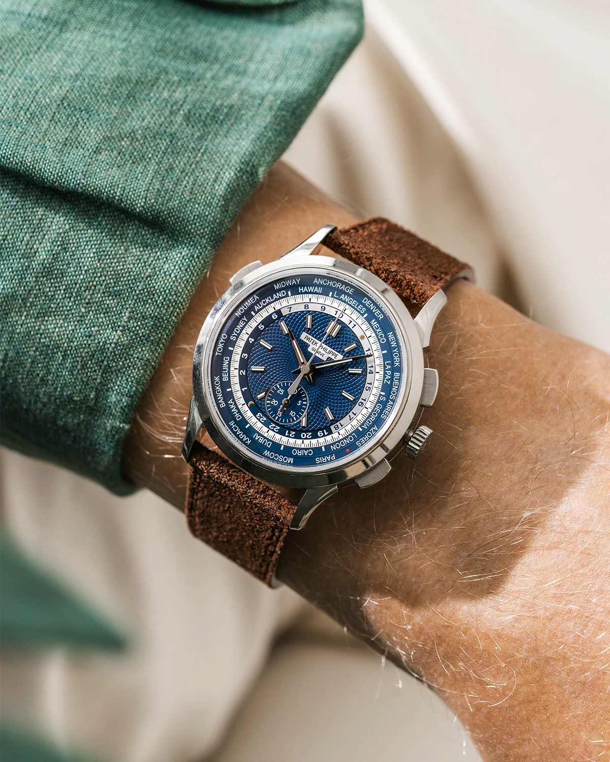 Patek Worldtimer with a blue face and brown suede leather watch strap from wristbuddys on a person's wrist.