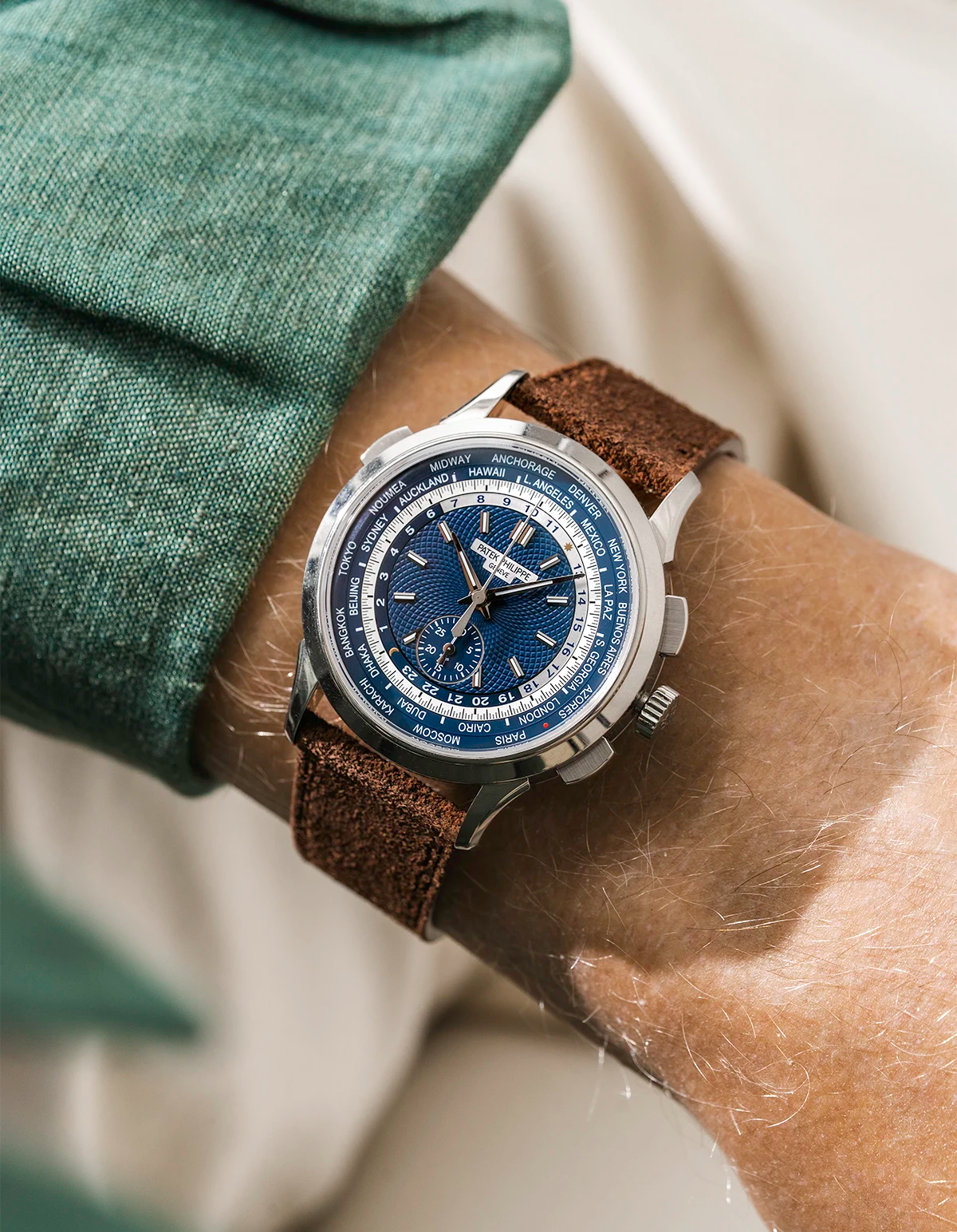 Patek Worldtimer with a blue face and brown suede leather watch strap from wristbuddys on a person's wrist.
