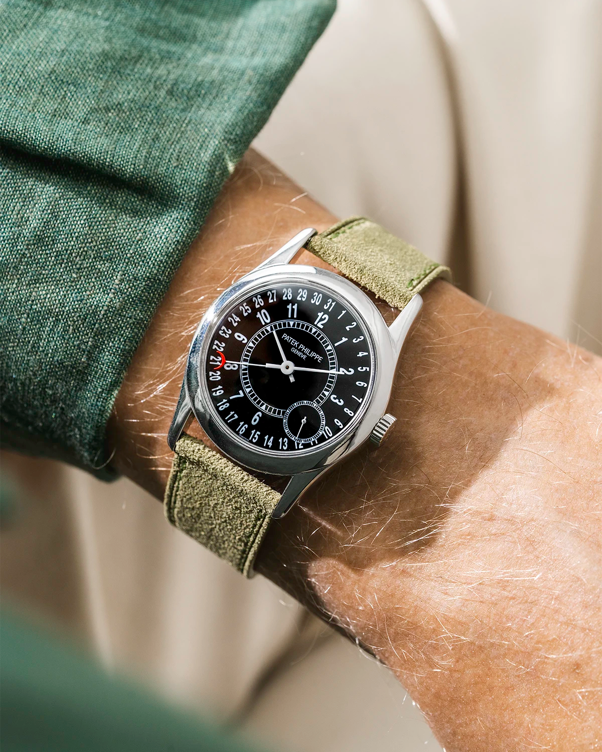 Patek with green suede watch strap from Wristbuddys on a person's wrist, close-up shot.