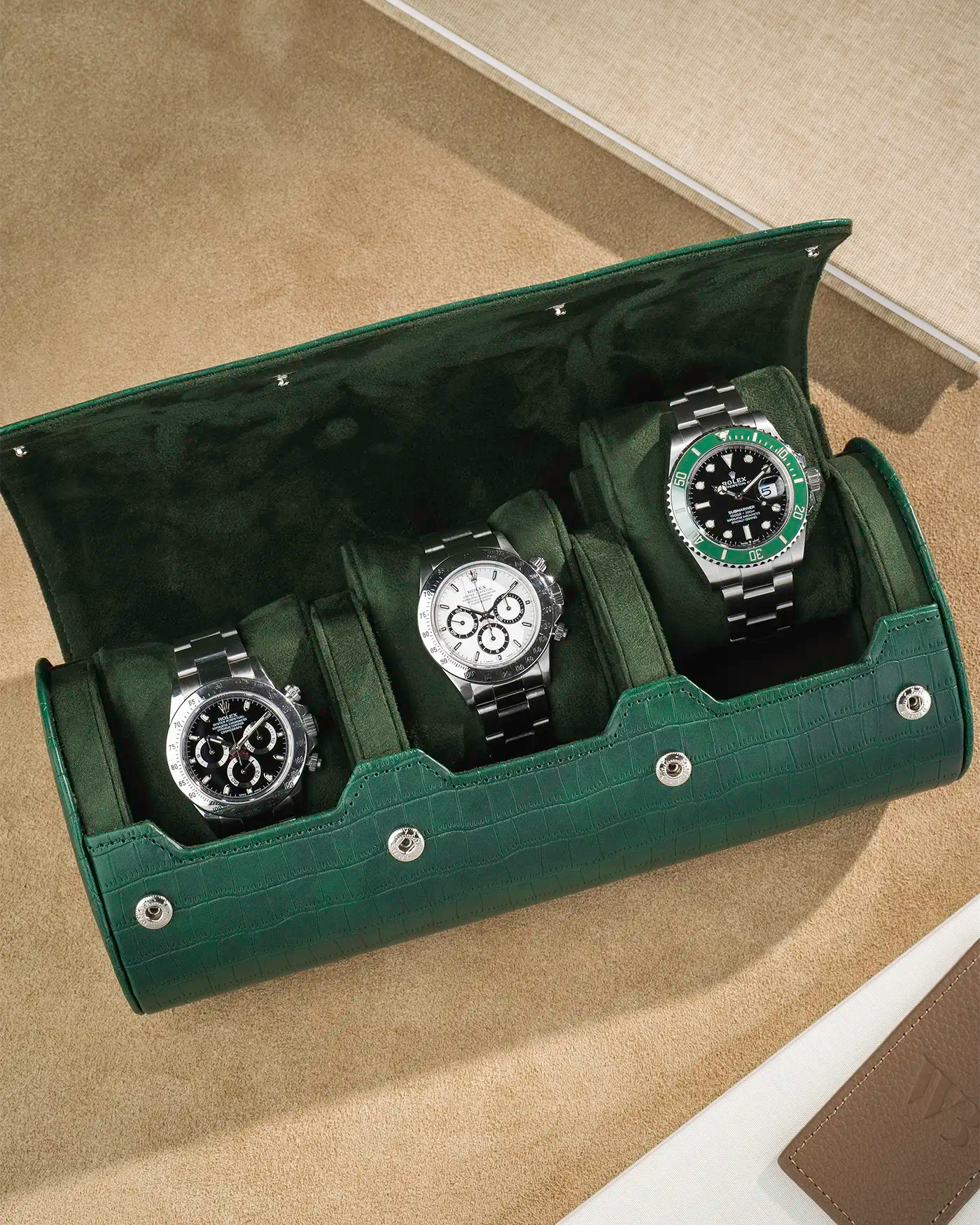 Opened green alligator 3 slot watch roll with 3 Rolex watches
