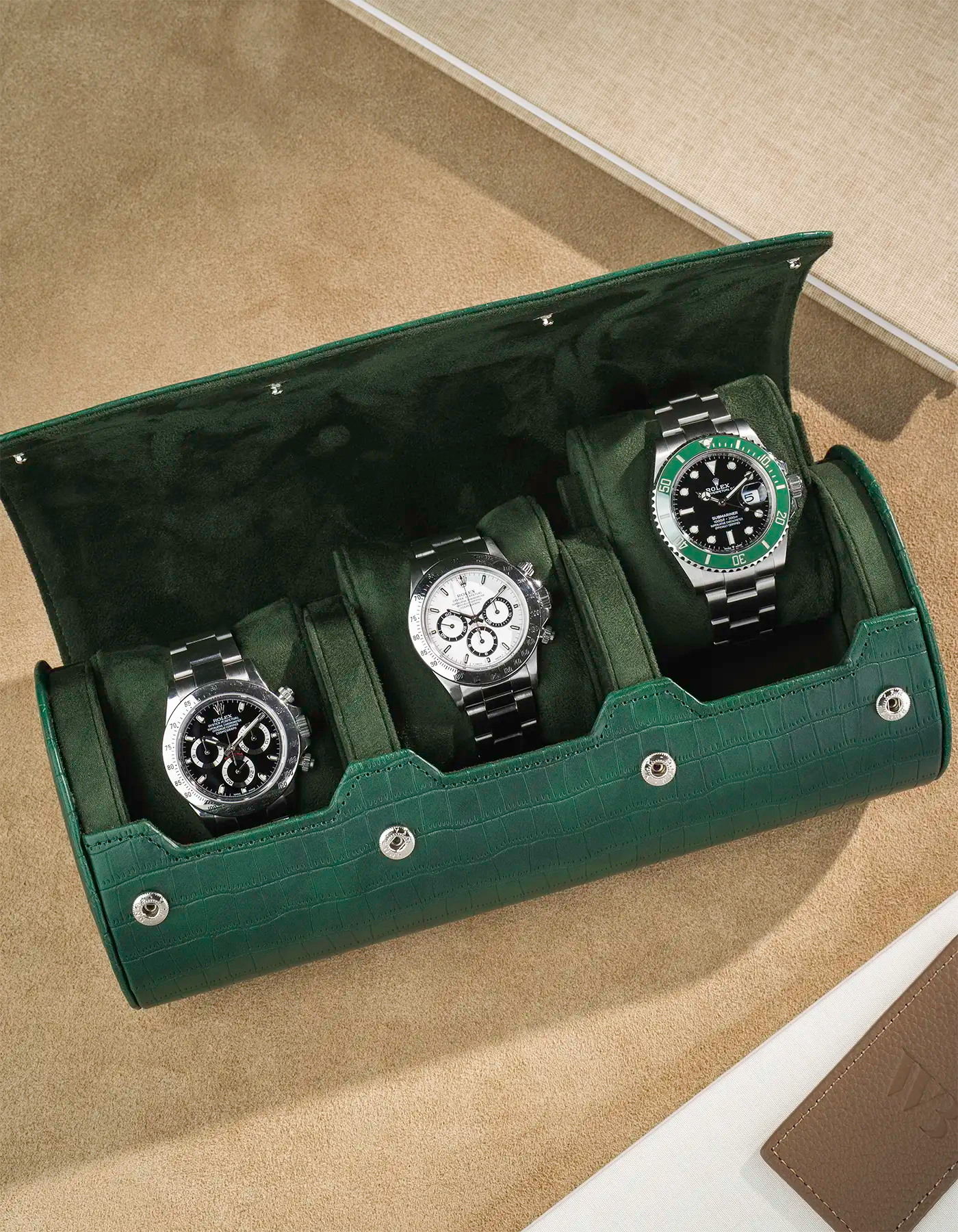 Opened green alligator 3 slot watch roll with 3 Rolex watches
