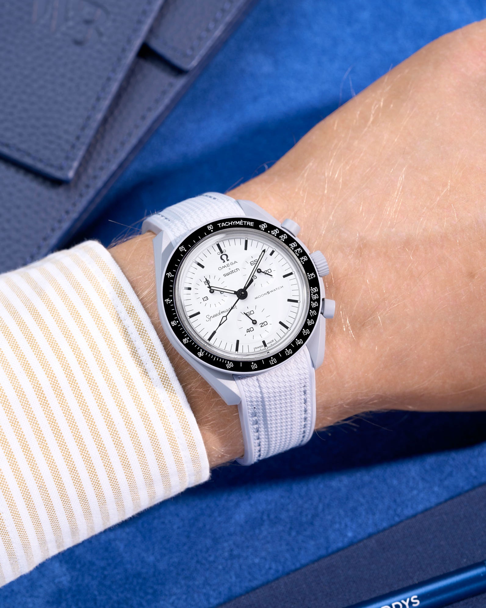 Omega X Swatch MoonSwatch 1965 watch with grey strap and white face on a blue background
