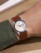 Rolex Daydate with diamond indexes watch with a brown alligator leather watch strap on a beige background